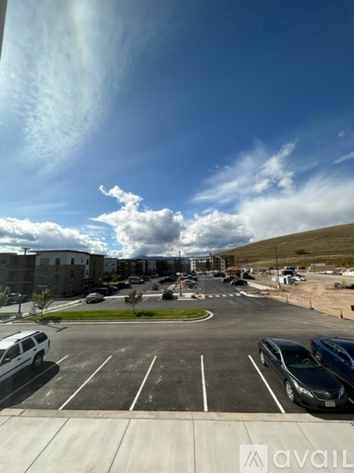 A parking lot with cars and a building in the background.