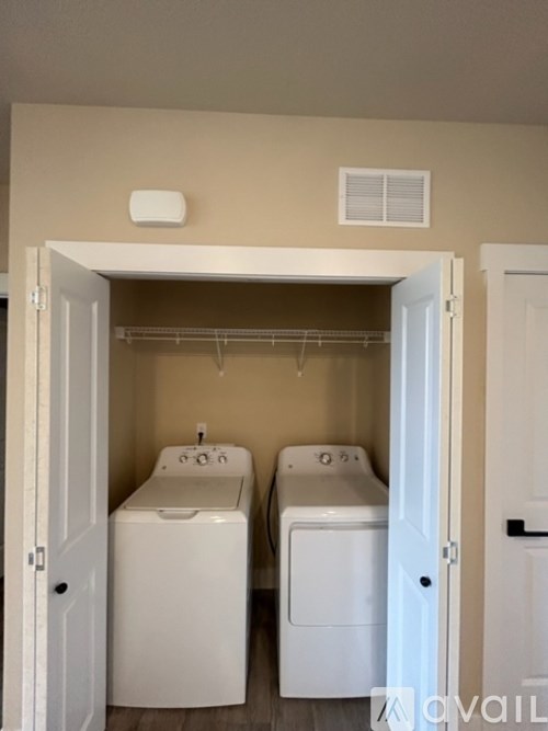 A laundry room with two washing machines and a white door.