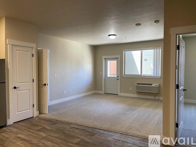 A spacious room with a door on the left and a window on the right.