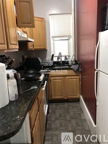 A kitchen with wooden cabinets and a black counter top.