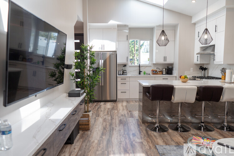 A modern kitchen with a bar area and a television.