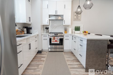 A modern kitchen with white cabinets and a central island.