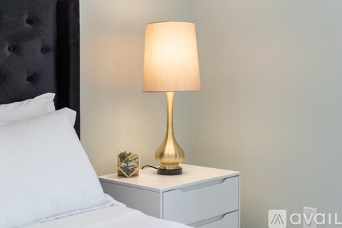 A bedside table with a lamp on it.
