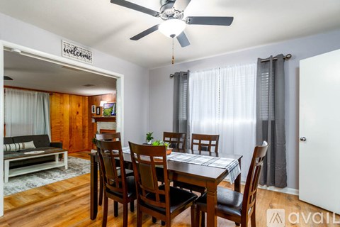 A dining room with a wooden table and chairs.