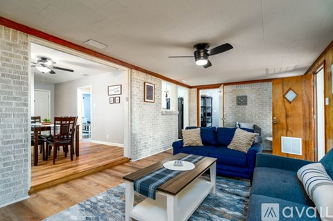 A living room with a blue couch and a wooden coffee table.
