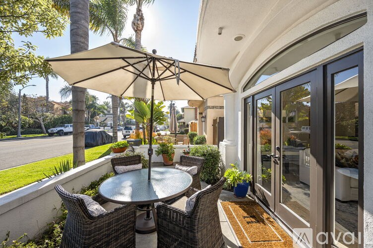 A patio with a table and chairs under an umbrella.