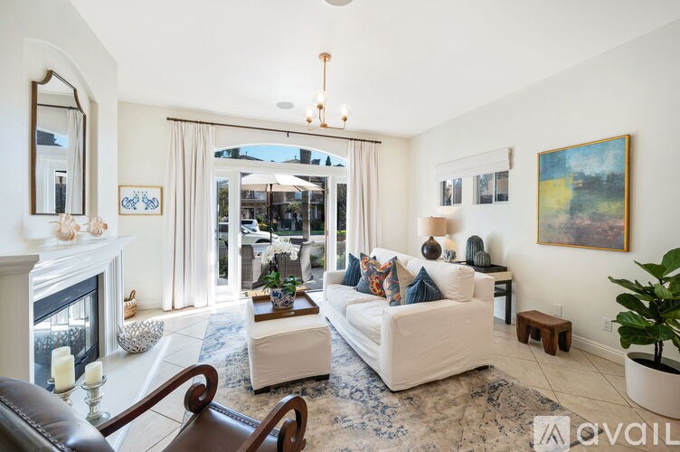 A living room with a fireplace, a sofa, a coffee table, and a painting on the wall.