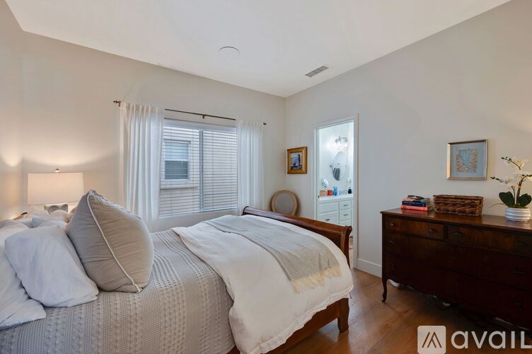 A bedroom with a large bed and a dresser.