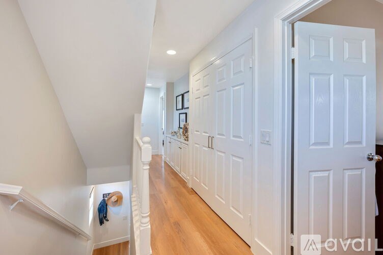 A hallway with white doors and a wooden floor.