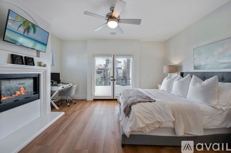 A bedroom with a large bed and a fireplace.