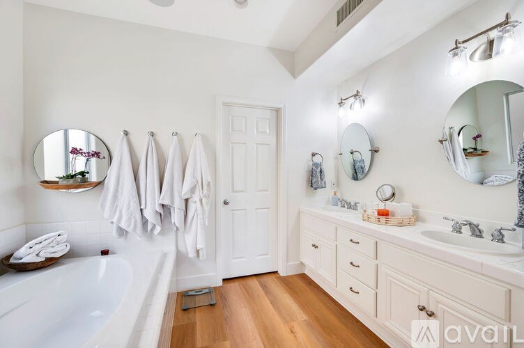 A bathroom with a white tub, sink, and towel rack.