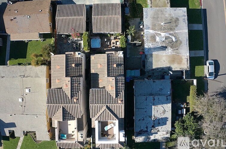 A bird's eye view of a residential area with houses and a car.