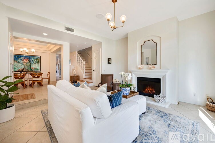 A living room with a white couch and a fireplace.
