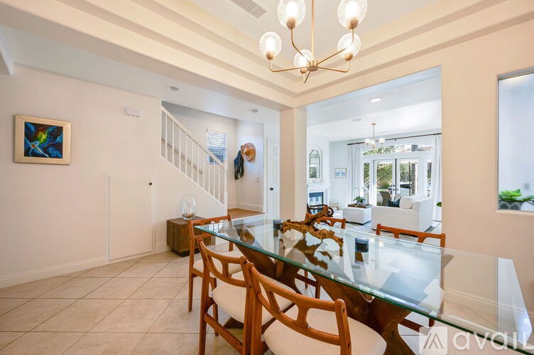 A dining room with a glass table and chairs.