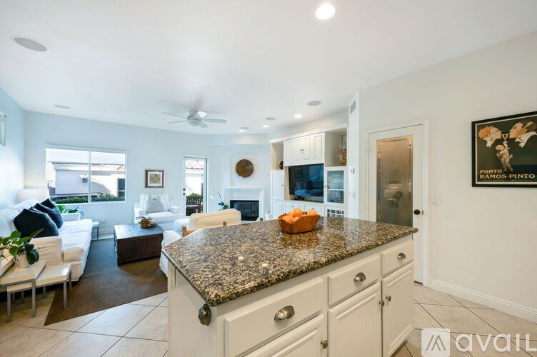 A kitchen with granite countertops and white cabinets.
