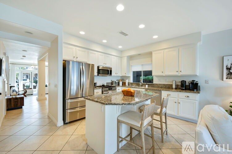A kitchen with a granite countertop and stainless steel appliances.