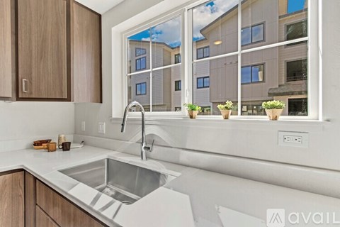 A modern kitchen with a stainless steel sink and wooden cabinets.