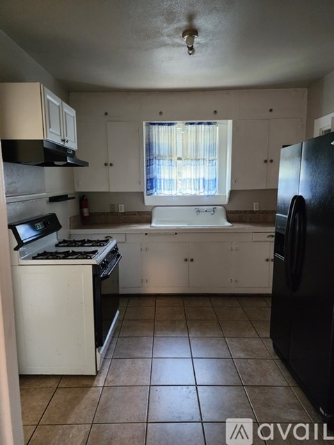 A kitchen with black appliances and white cabinets.