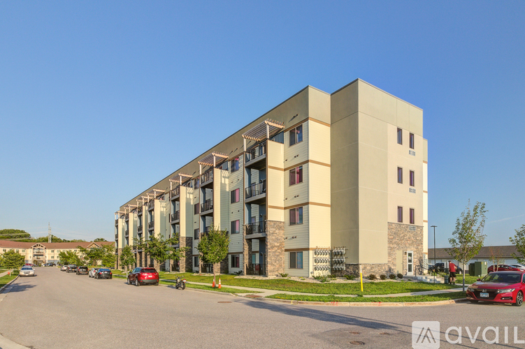 A modern apartment building with cars parked in front.