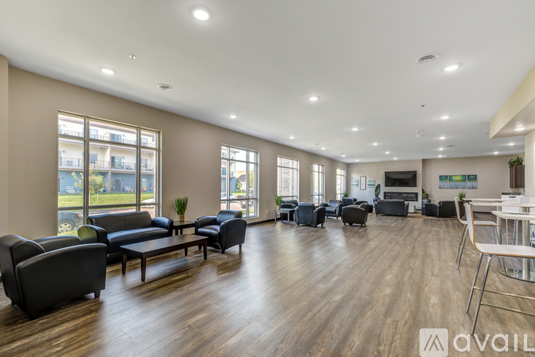 A spacious living room with a variety of seating options and a television.