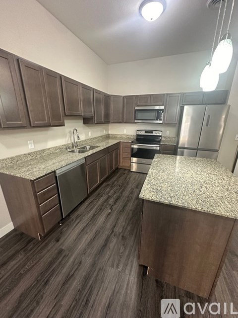 A kitchen with dark wood cabinets and granite countertops.