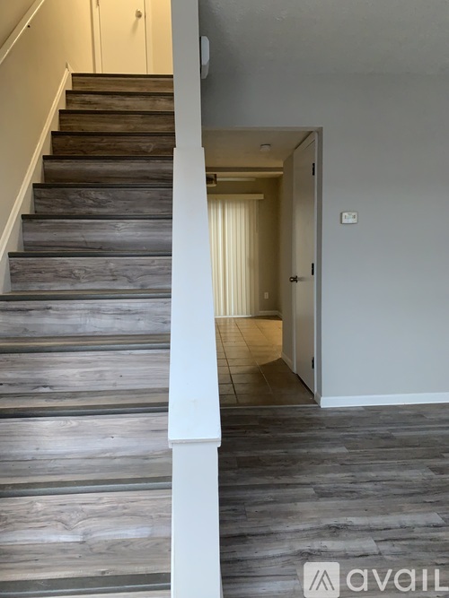 A hallway with a staircase and a door.