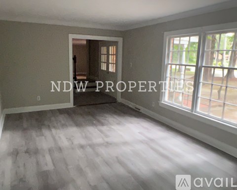 A room with a window and a door in the background.