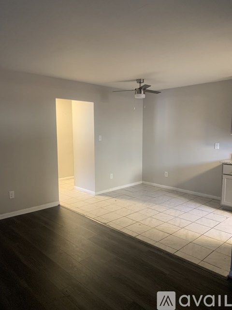 A room with a ceiling fan and a light on the wall.