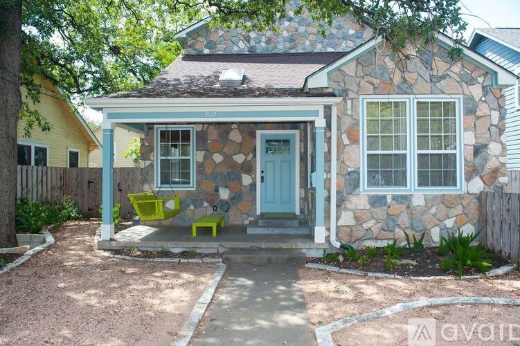 A house with a blue door and a stone wall.