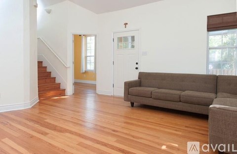 A living room with a couch and a staircase.