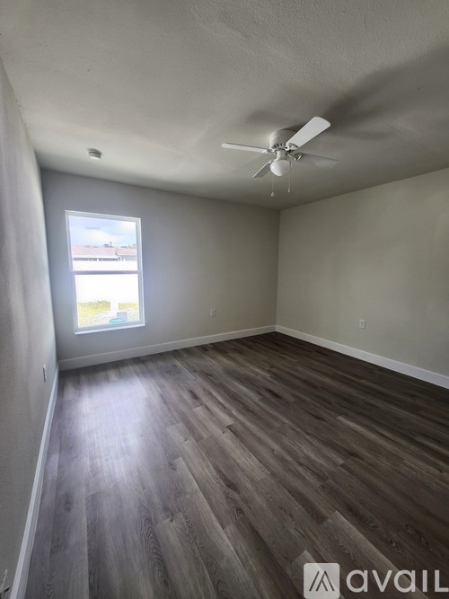 A room with a ceiling fan and a window.