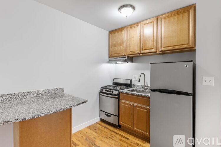A kitchen with a granite countertop and wooden cabinets.
