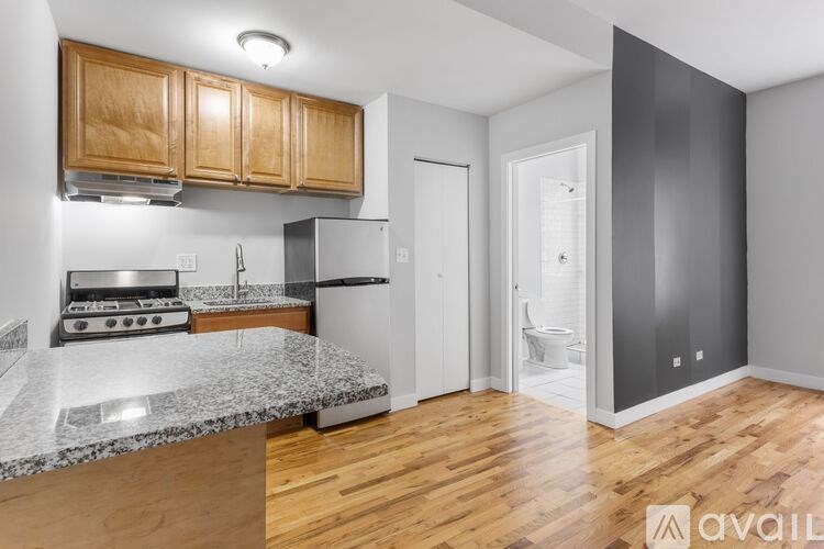 A kitchen with wooden cabinets and a marble countertop.