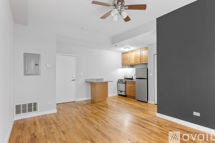 A spacious living room with a ceiling fan and hardwood floors.