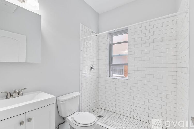 A white bathroom with a toilet, sink, and tiled walls.