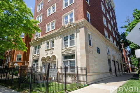 A tall building with a red brick facade and a white stone section in the middle.