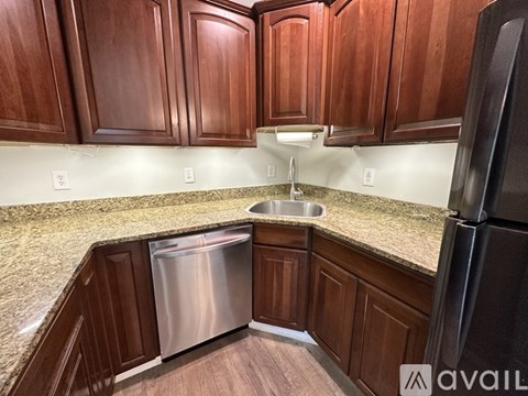 A kitchen with wooden cabinets and a granite countertop.