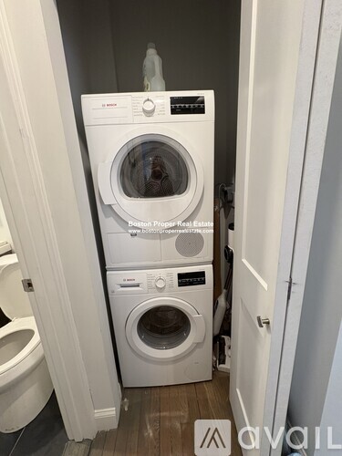 A white washing machine and dryer in a small laundry room.