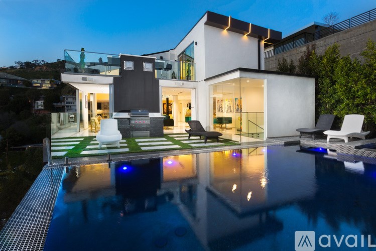 A modern house with a pool in front.