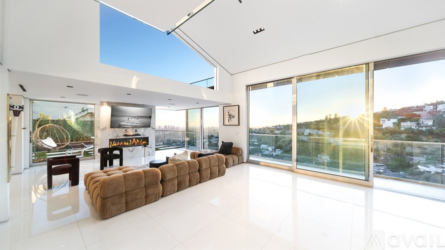 A modern house with a red car parked in front.