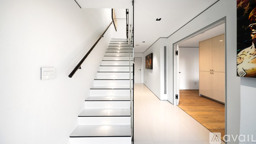 A modern house with a balcony overlooking a cityscape at dusk.