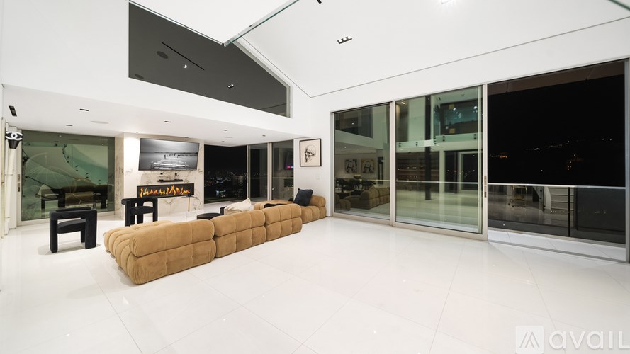 A living room with a fireplace and a view of the city.