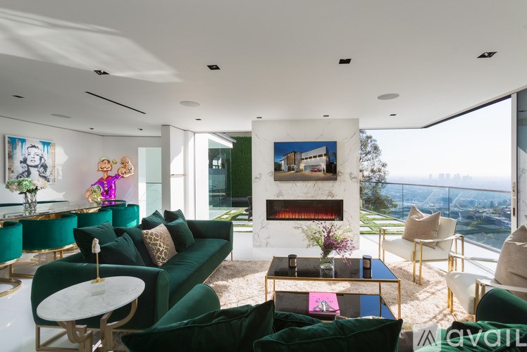 A living room with a green couch and a fireplace.