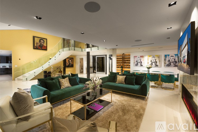 A living room with a green couch and a staircase.