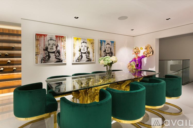 A modern dining room with a glass table and green chairs.