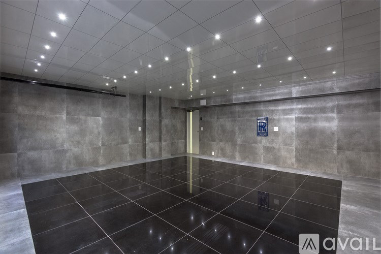 A spacious, empty lobby with a black tile floor and a wall of windows.