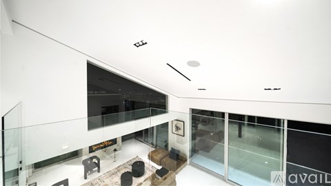 A modern bedroom with a large bed and a fireplace.