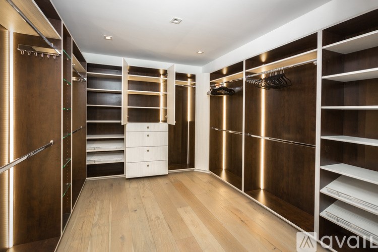 A walk-in closet with wooden shelves and drawers.