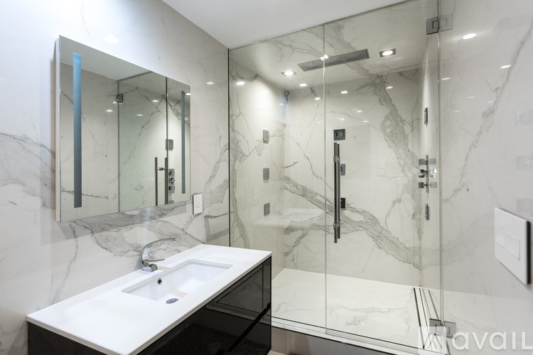A bathroom with a marble sink and mirror.