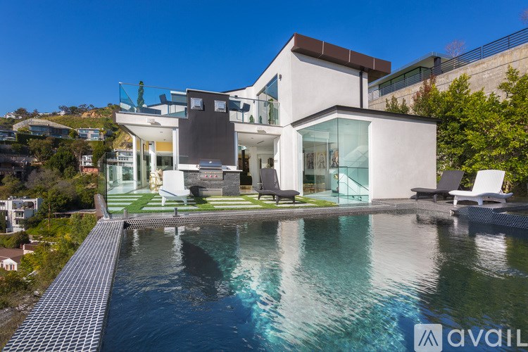A modern house with a pool in the foreground.